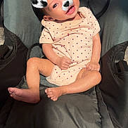 Annabella is registered to the contest to win money with this photo: baby, child, car_seat, infant, indoor, cute, smiling, dog_filter, face_filter, playful, clothing, onesie, seat, floor, happy, posing, young_child, human, head, legs