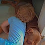 toddler, child, dog, sleeping, snuggling, brown_dog, blue_clothing, wooden_floor, indoors, peaceful, cute, pet, animal, young_child, relaxing, resting, doorway, affection, bonding, companion