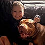 boy, child, dog, pet, smiling, happy, couch, indoor, leather, furniture, portrait, brown_dog, light, cozy, companionship, friendship, childhood, casual, warm, playful