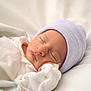 newborn, baby, sleeping, hat, white_clothing, blanket, soft, infant, resting, cute, peaceful, portrait, closeup, indoors, child, sleep, headwear, cozy, skin, wrapped