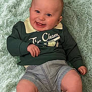Jaxon is registered to the contest to win money with this photo: baby, smiling, infant, child, clothing, sweater, shorts, barefoot, blanket, soft_texture, portrait, happy, cute, young, lying_down, skin, face, head, legs, indoors