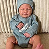 Waylon joined the competition — help win amazing prizes! baby, infant, knitted_clothing, blue_hat, blue_sweater, couch, plush, cream_color, peaceful, closed_eyes, foot, hand, relaxing, indoor, soft_texture, smiling, cute, cozy, child, portrait