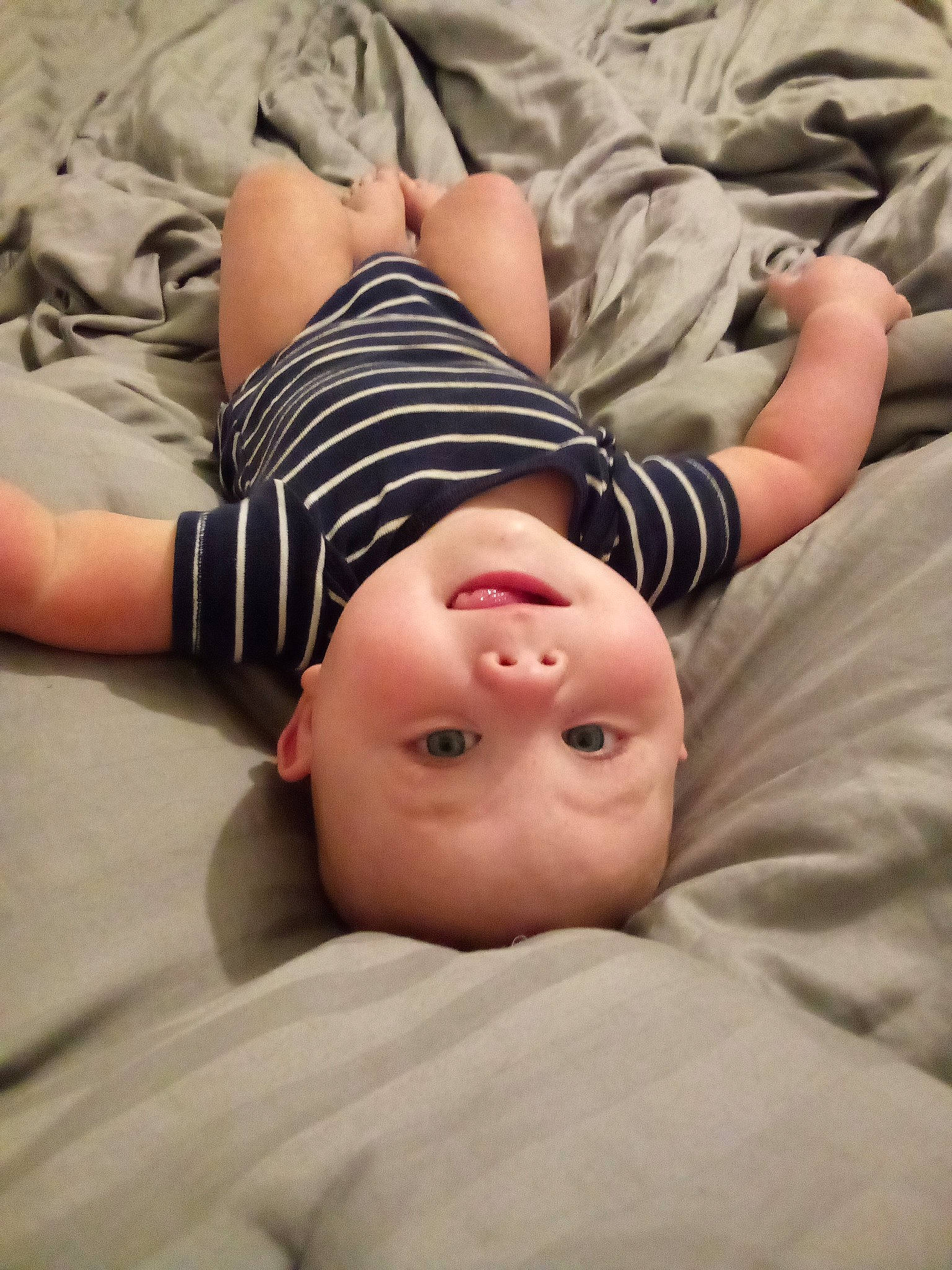 Emory is registered to the contest to win money with this photo: child, comfort, eye, facial_expression, flash_photography, flooring, happy, human_leg, knee, linens, lip, mouth, neck, pattern, person, sand, skin, sleeve, thigh, toddler