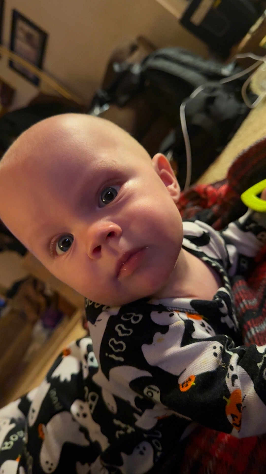 Dawson is registered to the contest to win money with this photo: baby, infant, face, eyes, onesie, clothing, ghost_pattern, indoor, portrait, child, cute, expression, person, head, skin, young, cozy, blanket, toy, curious