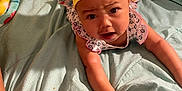 Jyleenia is registered to the contest to win money with this photo: baby, bed, blanket, blue, bonnet, clothing, curious, expression, face, hand, headband, indoor, infant, person, pillow, pineapple_pattern, pink, skin, tattoo, yellow