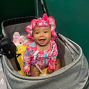 Jyleenia joined the competition — help win amazing prizes! baby, stroller, infant, smiling, happy, hat, clothing, bottle, baby_lotion, toy, indoor, person, child, face, sitting, accessory, pink, gray, yellow, cute