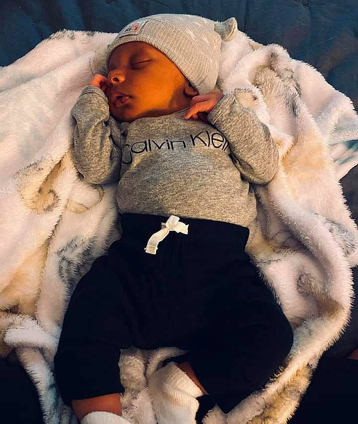 Grayson is registered to the contest to win money with this photo: baby, baby_products, baby_sleeping, baby_toddler_clothing, beanie, cap, child, comfort, fur, fur_clothing, headgear, headwear, knit_cap, linens, person, sitting, sleeve, textile, toddler, winter