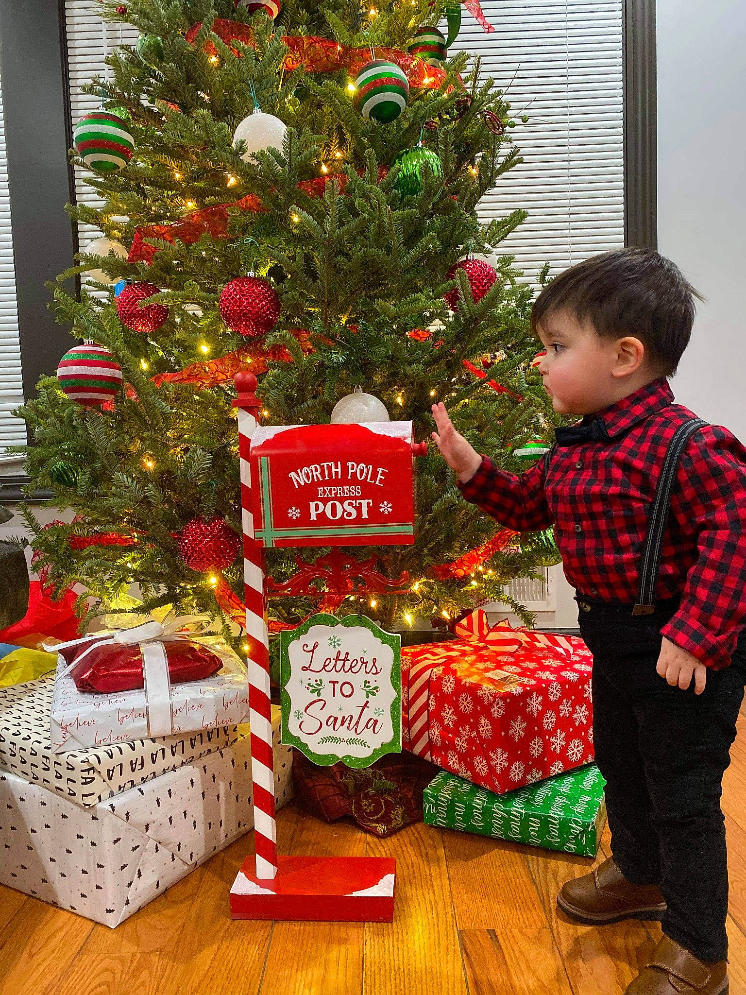 Jaxon is registered to the contest to win money with this photo: basket, christmas, christmas_decoration, christmas_eve, christmas_ornament, christmas_tree, conifer, decoration, event, evergreen, gift_wrapping, green, holiday, holiday_ornament, ornament, person, photograph, red, room, toddler