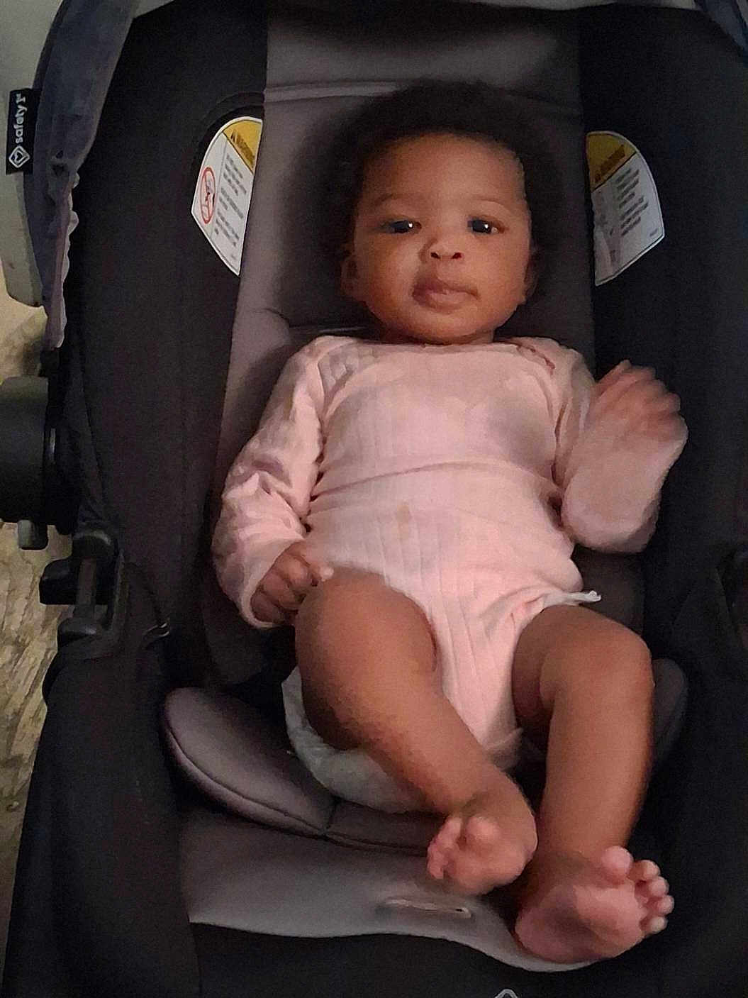 Miracle is registered to the contest to win money with this photo: baby, infant, child, car_seat, baby_carrier, onesie, pink_clothing, portrait, face, eyes, hands, feet, toes, hair, cute, relaxed, indoor, cozy, stroller, newborn
