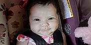 Allyana is registered to the contest to win money with this photo: baby, blanket, car_seat, child, child_safety, cute, dress, face, floral, happy, indoors, infant, person, pink, safety, seat, seatbelt, smile, toy, young_child
