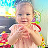 Allyana joined the competition — help win amazing prizes! baby, child, toddler, pink_dress, clapping_hands, indoor, toys, playroom, smiling, happy, face, person, cute, hair_up, patterned_clothing, furniture, colorful, television, young_child, clothing