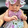 Allyana is registered to the contest to win money with this photo: baby, bonnet, bow, child, closeup, clothing, cute, cute_outfit, face, floral, hands, indoors, infant, person, pink, portrait, purple, sitting, skin, soft_light