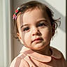 toddler, child, girl, portrait, sunlight, window, hair_clip, pink_dress, face, innocence, soft_shadows, brown_eyes, cute, indoors, closeup, curly_hair, serene, young_child, fashion, casual