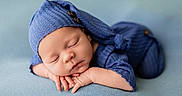 Jaxton is registered to the contest to win money with this photo: baby, baby_pose, blue_clothing, calm, child, closed_eyes, cozy, cute, hand_position, infant, knit_hat, knit_outfit, newborn, peaceful, portrait, resting, sleeping, soft_texture, studio_photo, tiny_fingers