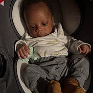 Nesai is registered to the contest to win money with this photo: baby, infant, pacifier, clothing, pants, booties, seat, cushion, indoor, child, young, cute, sleepy, relaxed, portrait, person, soft_lighting, cozy, small_hands, casual