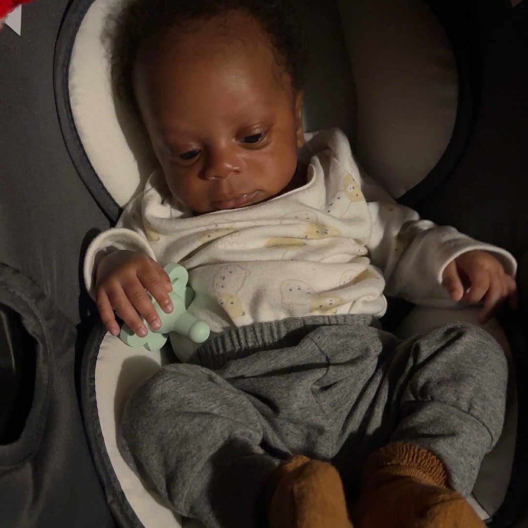 Nesai is registered to the contest to win money with this photo: baby, infant, pacifier, clothing, pants, booties, seat, cushion, indoor, child, young, cute, sleepy, relaxed, portrait, person, soft_lighting, cozy, small_hands, casual