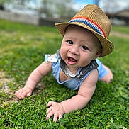 Jeffery joined the competition — help win amazing prizes! baby, child, hat, grass, outdoor, smiling, blue_clothing, face, crawling, nature, greenery, daytime, happy, cute, person, headwear, infant, grass_field, sunny, playing
