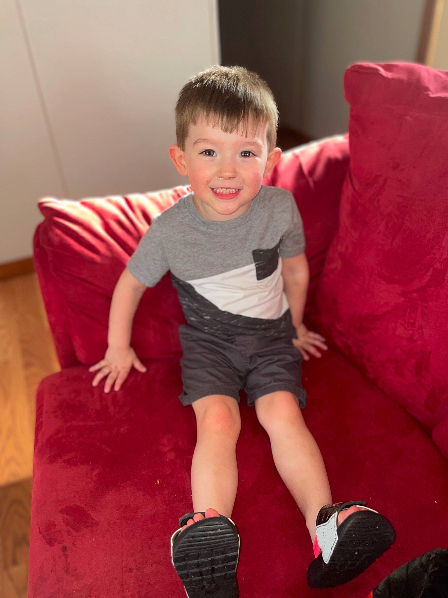 Axel is registered to the contest to win money with this photo: baby_toddler_clothing, comfort, finger, flash_photography, flooring, fun, happy, human_leg, joy, knee, lap, mammal, person, red, shorts, sleeve, smile, sock, t_shirt, thigh