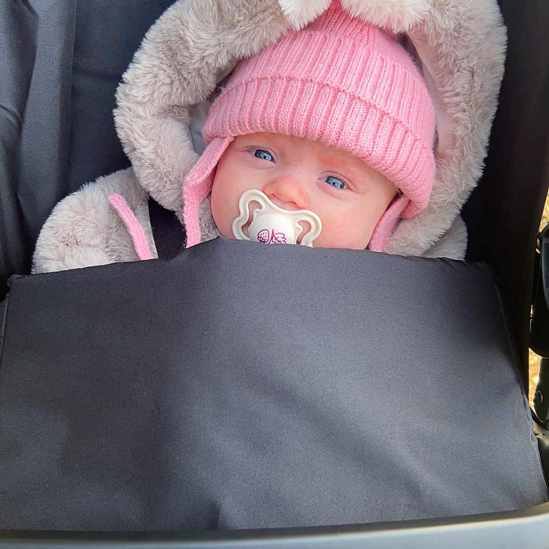 Remmie joined the competition — help win amazing prizes! baby, baby_stroller, blanket, blue_eyes, bundle, child, cozy, cute, face, fur_hood, graco, headwear, infant, outdoor, pacifier, person, pink_hat, stroller, warm_clothing, winter_wear
