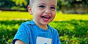 Zayan a rejoint le concours — aidez-le/la à gagner de superbes lots ! blanket, blue_shirt, boy, casual_clothing, child, cute, daylight, grass, greenery, happy, laughter, nature, outdoor, playful, portrait, sitting, smiling, sunlight, toddler, young