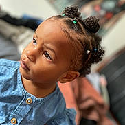 Tziraea joined the competition — help win amazing prizes! child, toddler, baby, portrait, face, smiling, curious, looking_up, denim, dress, hair_buns, braids, hair_ties, indoor, close_up, photography, soft_focus, colorful, sitting, family