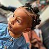 child, toddler, baby, portrait, face, smiling, curious, looking_up, denim, dress, hair_buns, braids, hair_ties, indoor, close_up, photography, soft_focus, colorful, sitting, family