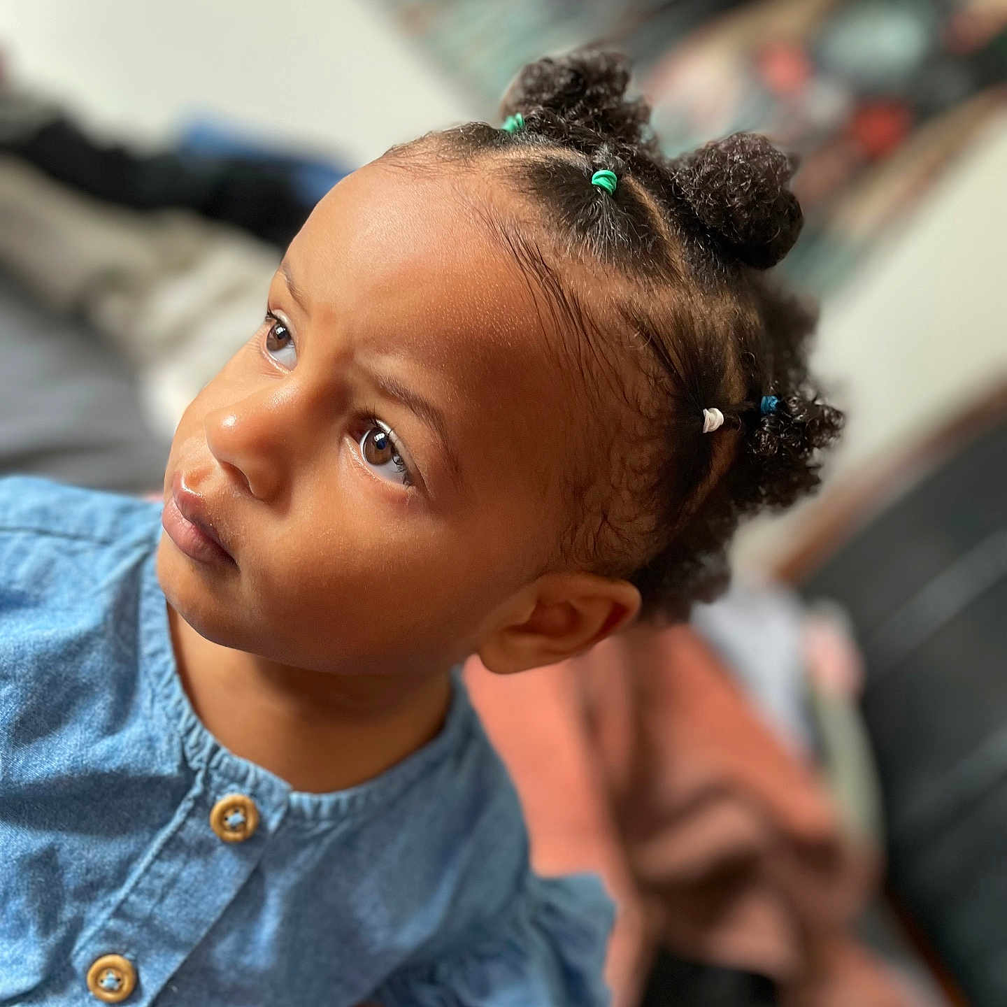 Tziraea joined the competition — help win amazing prizes! child, toddler, baby, portrait, face, smiling, curious, looking_up, denim, dress, hair_buns, braids, hair_ties, indoor, close_up, photography, soft_focus, colorful, sitting, family