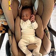 Soän participe au concours pour gagner de l'argent avec cette photo : baby, sleeping, car_seat, pajamas, infant, child, stroller, floor, toy, footwear, brown, cream, comfort, indoor, head_support, rest, peaceful, padding, clothing, person