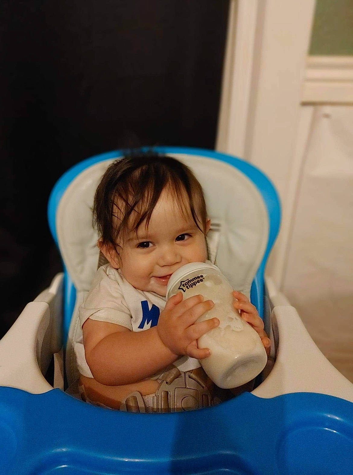 Gionni is registered to the contest to win money with this photo: baby, baby_bottle, baby_products, baby_toddler_clothing, blue, child, comfort, curtain, drinkware, fun, happy, joy, leisure, milk, person, plastic, plastic_bottle, play, product, sitting