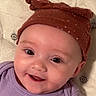 baby, smiling, face, hat, brown_hat, purple_clothing, infant, cute, child, eyes, happy, portrait, close_up, headwear, baby_girl, soft_fabric, background, skin, cheeks, expression