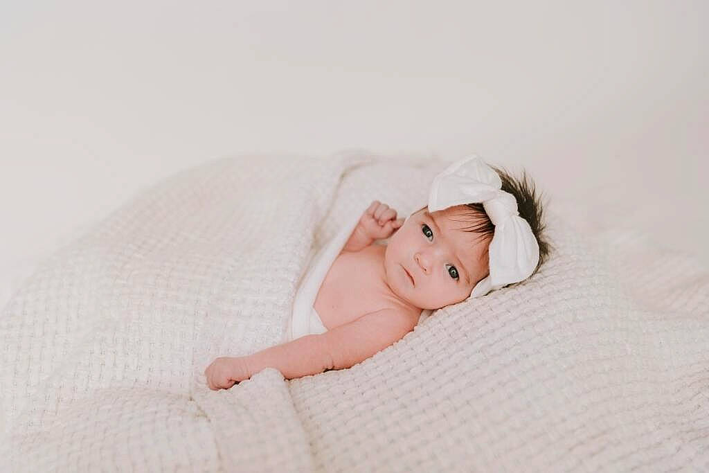 Marlee joined the competition — help win amazing prizes! baby, baby_toddler_clothing, bedding, child, collar, comfort, fashion_accessory, flash_photography, flooring, hair_accessory, happy, headwear, linens, pattern, person, petal, photo_shoot, portrait_photography, room, sitting