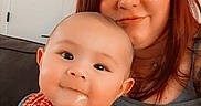 Benji joined the competition — help win amazing prizes! baby, woman, red_hair, checkered_clothing, drool, indoor, couch, smile, portrait, closeup, person, holding, casual_clothing, face, happy, child, mother_and_child, skin, furniture, home