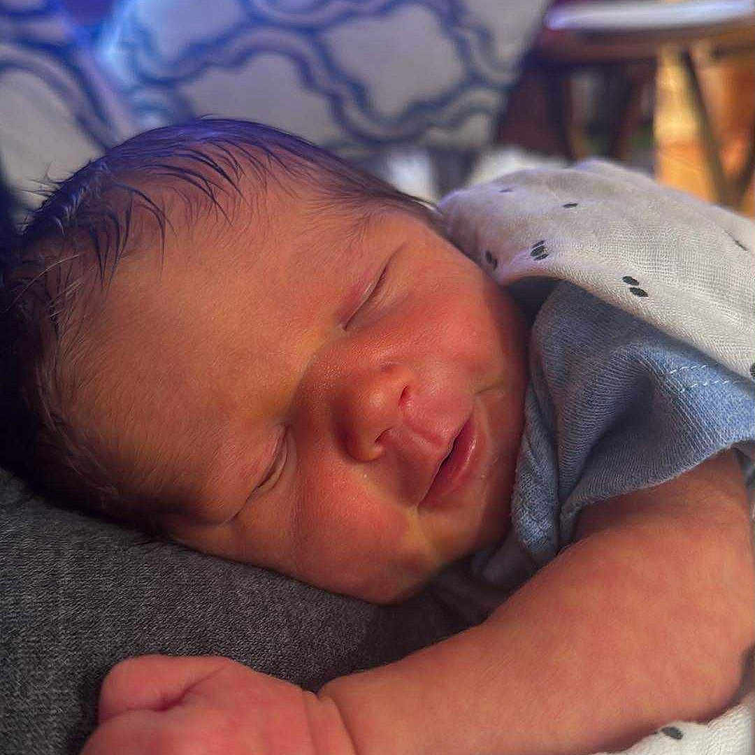 John Benjamin is registered to the contest to win money with this photo: baby, blanket, child, closeup, cozy, cute, face, hand, indoors, infant, newborn, peaceful, person, portrait, rest, skin, sleeping, soft, warm, young