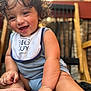Micaden joined the competition — help win amazing prizes! toddler, child, smiling, happy, curly_hair, bib, clothing, sitting, barefoot, face, arm, foot, person, indoor, wooden_chair, blurred_background, natural_light, cute, expression, baby