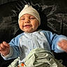 Aziel joined the competition — help win amazing prizes! baby, infant, child, smiling, portrait, indoors, blanket, hat, beanie, blue_outfit, white_clothing, sitting, lying_down, cozy, happy, face, hands, baby_clothing, soft_lighting, closeup