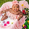 baby, infant, milk_bath, pink_clothing, flower_headband, flowers, greenery, bracelets, smiling, cute, soft_fabric, outdoor, nature, skin, water, ruffles, portrait, happy, child, sitting