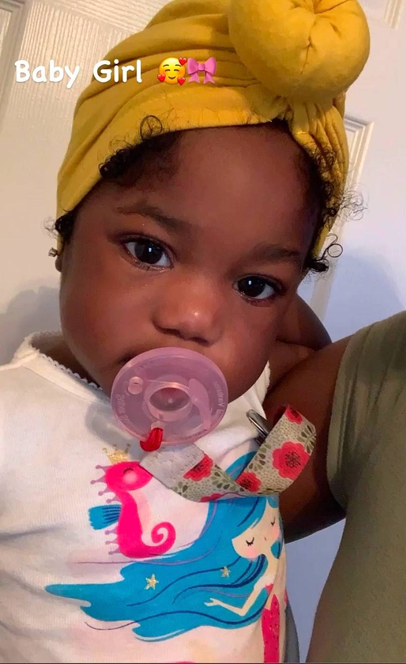 Lea is registered to the contest to win money with this photo: baby, baby_toddler_clothing, cheek, child, drinkware, eye, eyelash, facial_expression, happy, head, helmet, iris, lip, mouth, nose, organ, party_supply, person, pink, skin