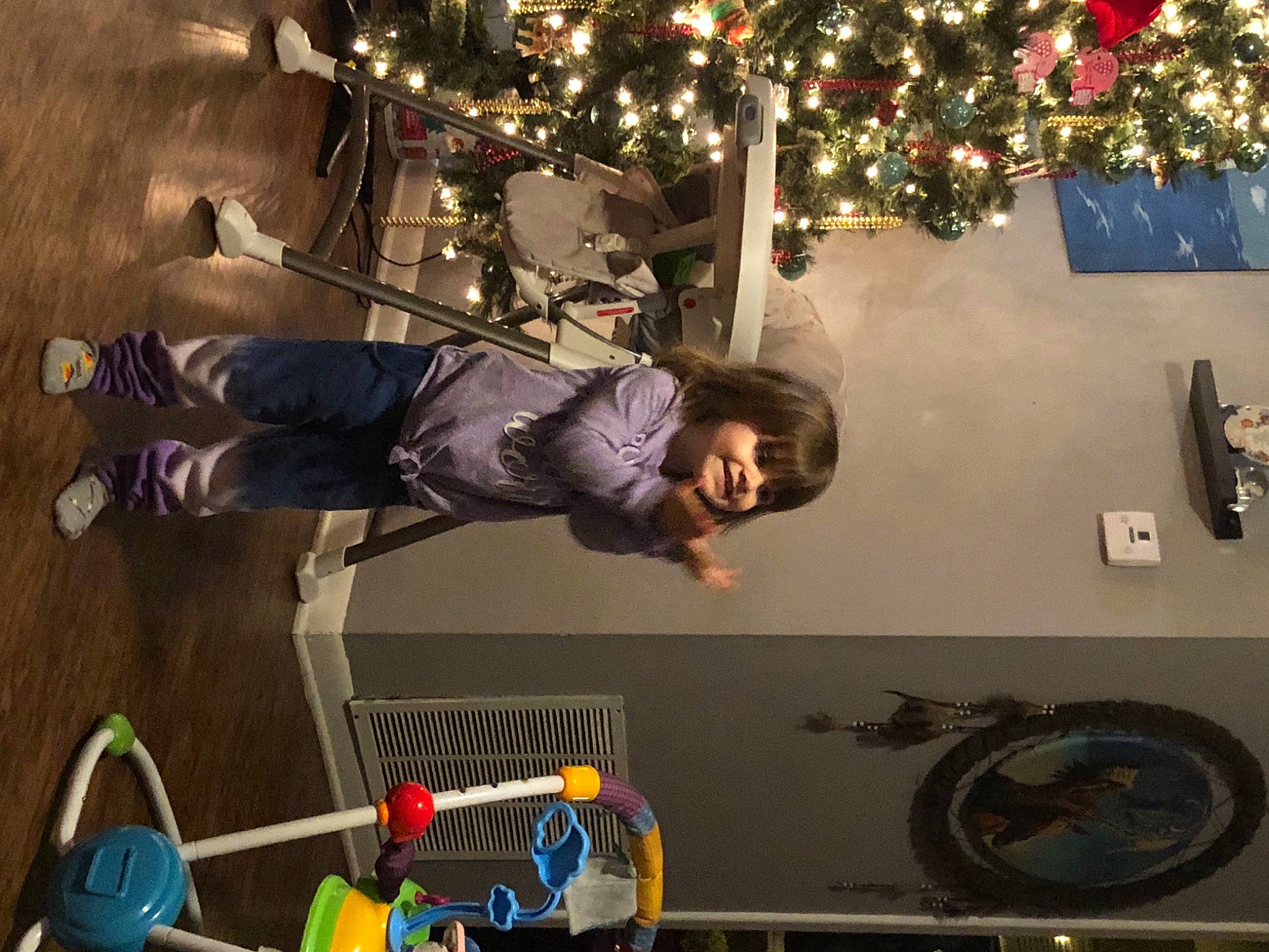 Olivia is registered to the contest to win money with this photo: boot, child, christmas_decoration, christmas_ornament, christmas_tree, entertainment, event, fun, holiday, joy, leisure, light, ornament, person, plant, room, smile, snapshot, space, t_shirt
