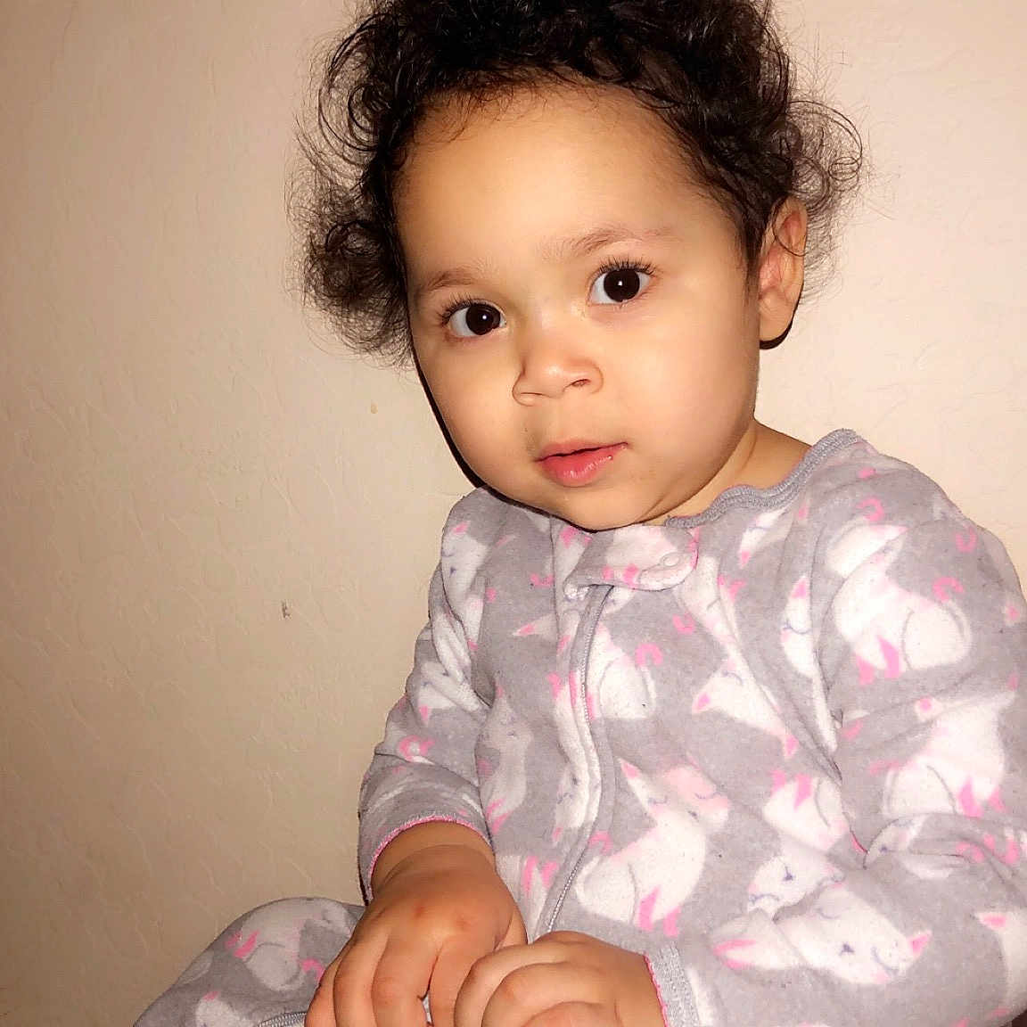 Isabella is registered to the contest to win money with this photo: arm, baby, black_hair, cheek, child, chin, eye, face, hair, head, iris, lip, neck, nose, person, pink, sitting, skin, smile, standing