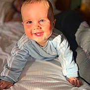 Malo participe au concours pour gagner de l'argent avec cette photo : baby, child, crawling, bed, blue_clothing, smiling, happy, face, hands, indoor, sunlight, blurred_background, person, infant, cute, portrait, young_child, home, cozy, soft_light