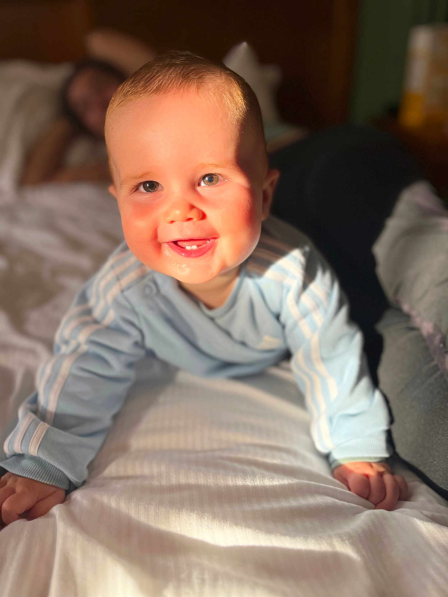Malo participe au concours pour gagner de l'argent avec cette photo : baby, child, crawling, bed, blue_clothing, smiling, happy, face, hands, indoor, sunlight, blurred_background, person, infant, cute, portrait, young_child, home, cozy, soft_light