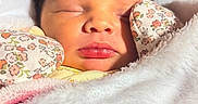Ariannah is registered to the contest to win money with this photo: baby, newborn, sleeping, blanket, mittens, floral, face, closeup, soft, cozy, infant, peaceful, cute, wrapped, skin, warm_light, indoors, portrait, child, resting