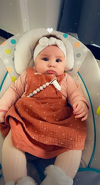 Mia a rejoint le concours — aidez-le/la à gagner de superbes lots ! baby, baby_products, baby_toddler_clothing, baby_toys, chair, cheek, child, comfort, doll, eyelash, hairstyle, head, headwear, peach, person, pink, room, sitting, skin, textile