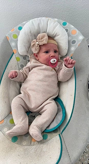 Mia a rejoint le concours — aidez-le/la à gagner de superbes lots ! baby, baby_products, baby_safety, baby_sleeping, baby_toddler_clothing, cap, cheek, child, comfort, eye, fashion_accessory, headwear, linens, person, pink, room, sitting, skin, sleeve, smile