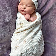Ayvalynn Snuggs is registered to the contest to win money with this photo: newborn, baby, sleeping, wrapped, blanket, headband, face, infant, soft, purple, plush, cozy, peaceful, cute, child, portrait, resting, swaddle, clothing, toddler