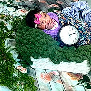 Estrella joined the competition — help win amazing prizes! baby, infant, blanket, clock, floral, greenery, flowers, headband, pink_bow, cushion, wooden_floor, decorative, portrait, indoors, cute, resting, soft_texture, colorful, peaceful, young_child
