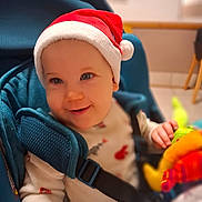 Agathe a rejoint le concours — aidez-le/la à gagner de superbes lots ! baby, blue_car_seat, child, clothing, cute, face, festive, hand, happy, holiday, indoor, infant, person, plush_toy, portrait, red_hat, santa_hat, seatbelt, smile, toy
