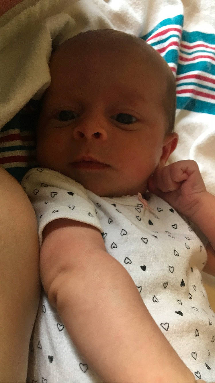 Kathleen is registered to the contest to win money with this photo: arm, baby, baby_toddler_clothing, cheek, comfort, eye, eyebrow, face, finger, forehead, head, iris, lip, mammal, mouth, neck, nose, person, product, skin