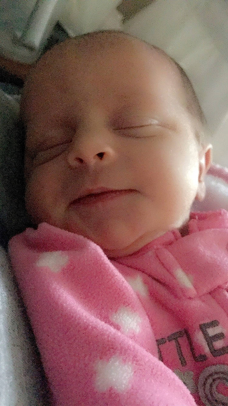 Kathleen is registered to the contest to win money with this photo: baby, baby_toddler_clothing, cheek, chin, comfort, eye, eyebrow, eyelash, face, head, iris, lip, mouth, neck, nose, person, pink, skin, sleeve, smile