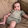 baby, infant, couch, onesie, smile, chubby_cheeks, relaxed, indoor, soft_fabric, wooden_buttons, cute, child, person, skin, seat, comfort, portrait, happy, young, cozy